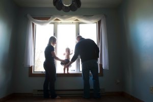 one year old in window with parents